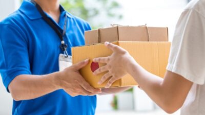 Woman hand accepting a delivery of boxes from deliveryman